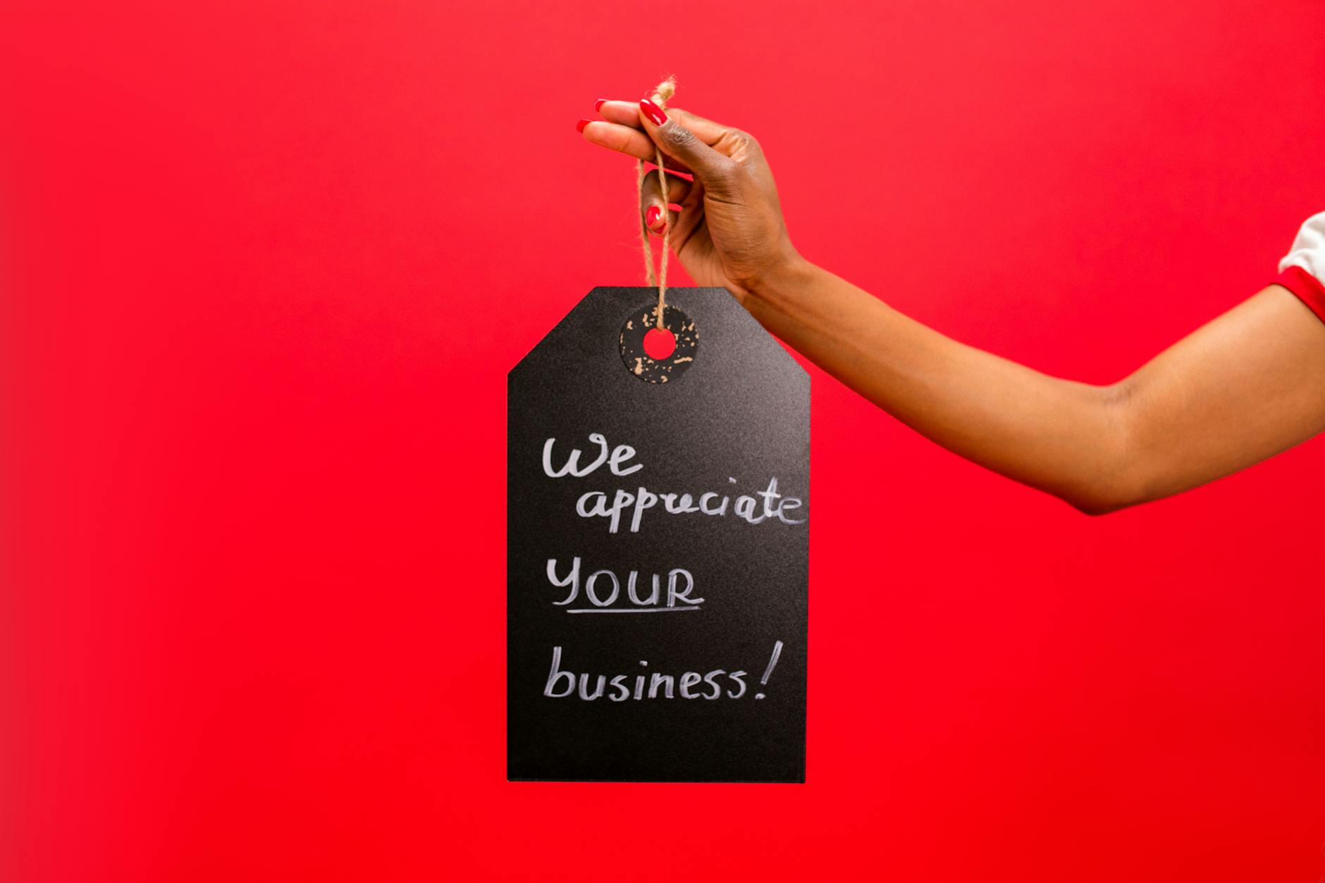 person holding a chalkboard with a text saying we appreciate your business