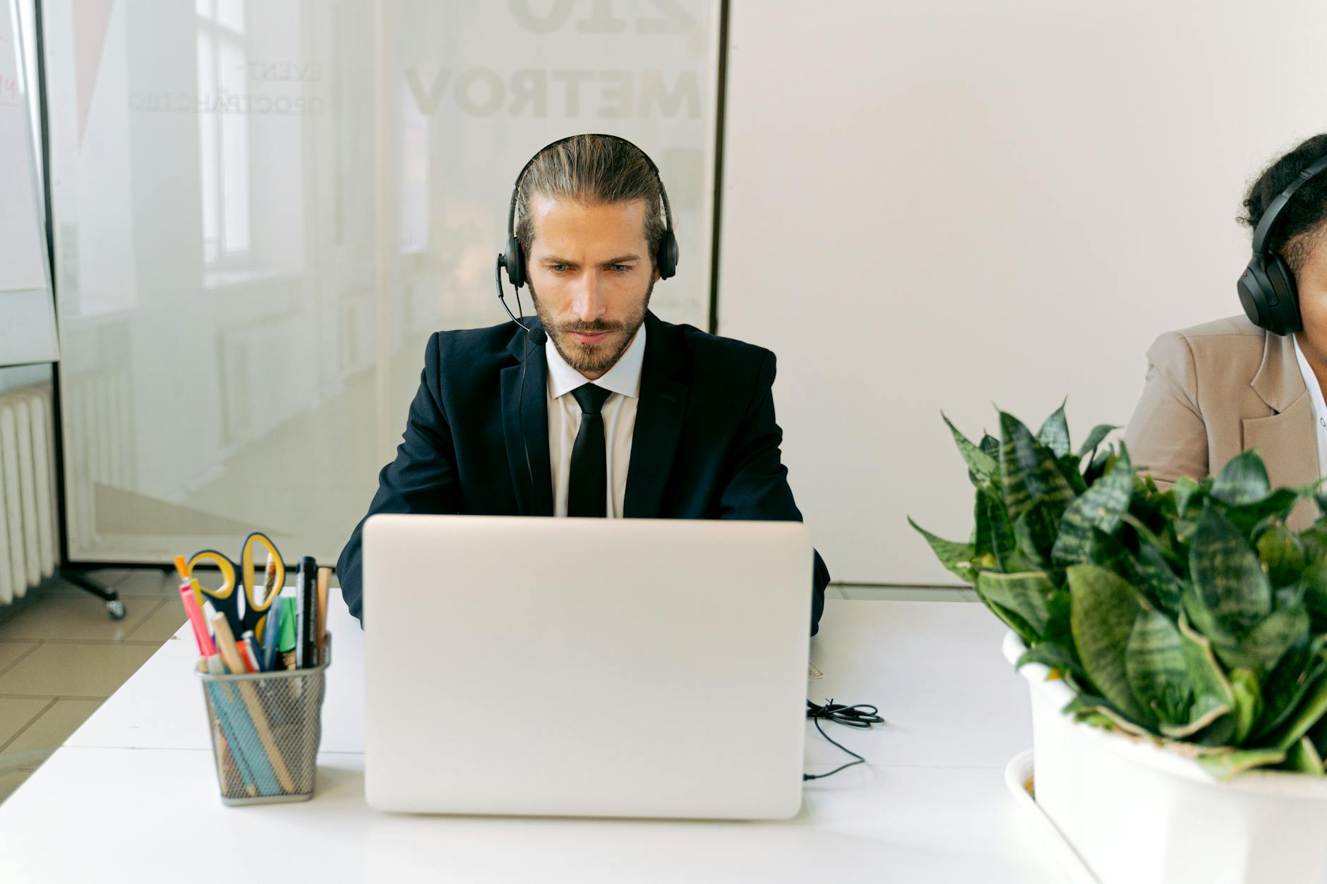 man in black suit jacket using laptop
